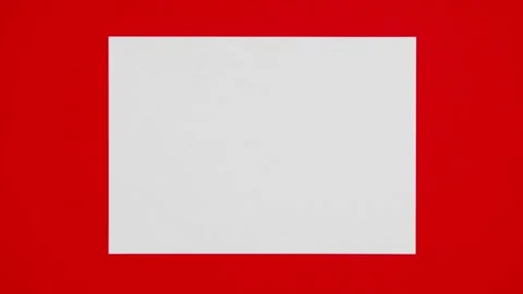Blank sheet of white paper appears on red background from a paper ball Stock Footage 259939363
