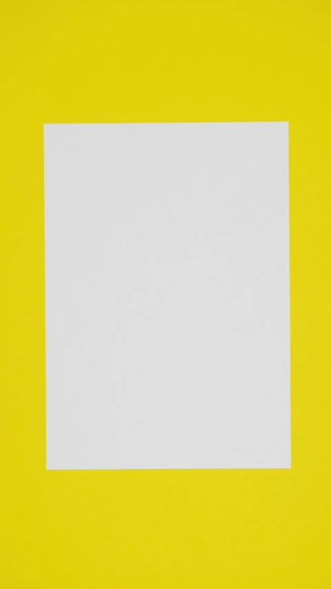 Blank sheet of white paper appears on yellow vertical background Stock Footage 265874524