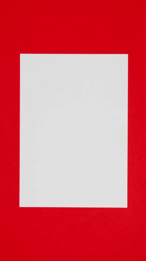 Blank sheet of white paper appears on red vertical background from a paper ball Stock Footage 270089387