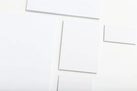 Blank sheets of paper arranged in a creative pattern on a white background Stock Photos