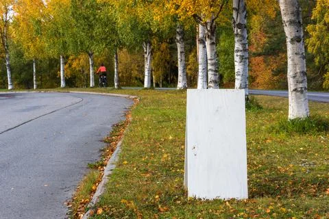 Blank sign with copy space on grass between a street and a cycle path Stock Photos
