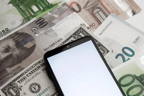 A blank smartphone screen on the background of various paper money Stock Photos