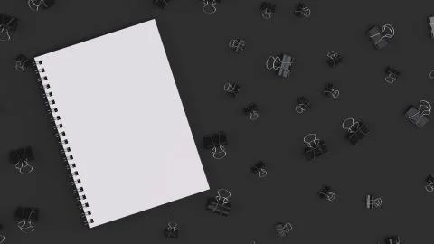 Blank spiral notebook with black binder clips on black table Stock Illustration