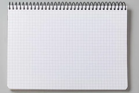 Blank squared sheet of exercise book with wire spiral binding Stock Photos