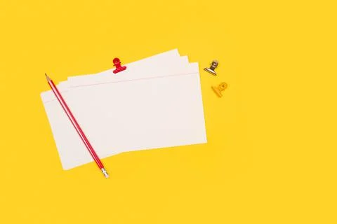 Blank striped paper notes with a red pencil on a yellow background with copy Stock Photos