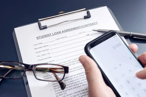 Blank Student Loan Application on table and hand holding a smartphone with... Stock Photos