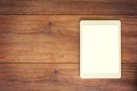 Blank Tablet computer on wood table background with space for text. Stock Photos