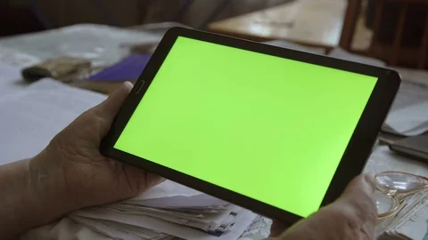 A blank tablet PC in landscape orientation with a green screenin hands. 4k Vidéo 71782347