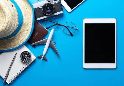Blank tablet screen on blue background with summer travel accessories 库存照片