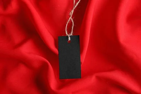 Blank tag with string on red fabric, top view Stock Photos