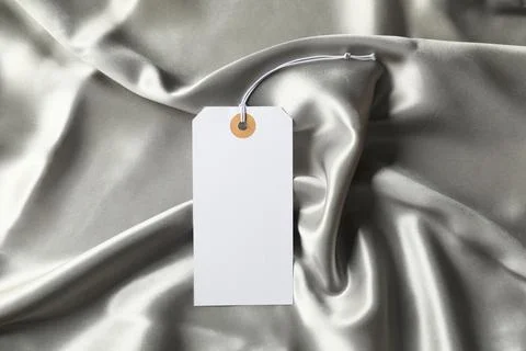 Blank tag with string on silver fabric, top view 스톡 사진