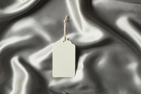 Blank tag with string on silver fabric, top view 스톡 사진