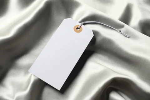 Blank tag with string on silver fabric, above view 스톡 사진
