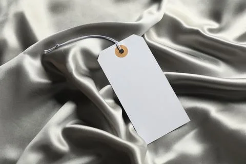 Blank tag with string on silver fabric, above view 스톡 사진