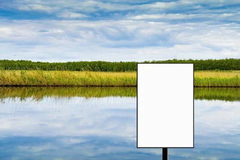 Blank vertical billboard against the backdrop of the river and the cloudy sky Stock Illustration