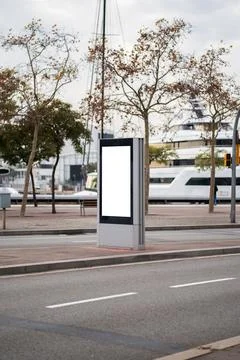 Blank vertical digital screen display mockup positioned in a modern urban street Stock Photos