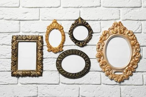 Blank vintage frames hanging on white brick wall. Mockup for design Stock Photos