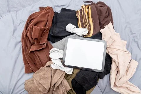Blank white board notebook with copy space for text on pile clothes backgroun Stockfoto's