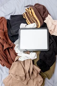 Blank white board notebook with copy space for text on pile clothes backgroun Stockfoto's