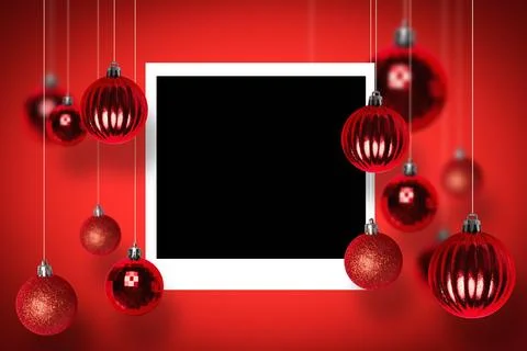 Blank white-bordered frame is being surrounded by red baubles on silver strings Stock Photos