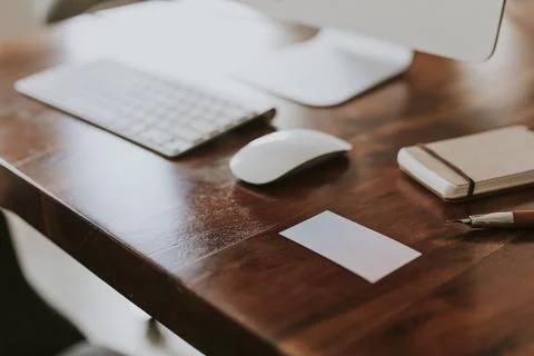 Blank white card next to computer keyboard on a wooden table 写真素材