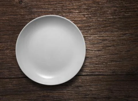 Blank white ceramic round dish on wooden desk background Stock Photos