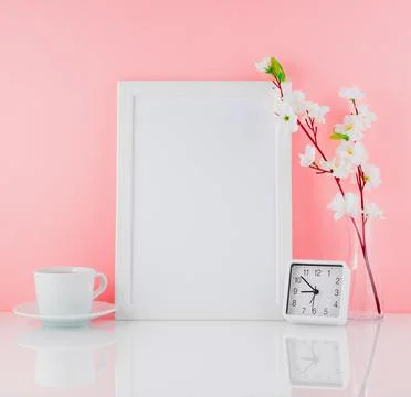 Blank white frame, flower, clock and cup of coffee or tea on whi Stock Photos