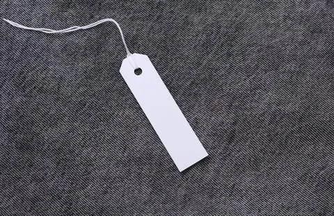 Blank white luggage tag with string on dark background Stock Photos