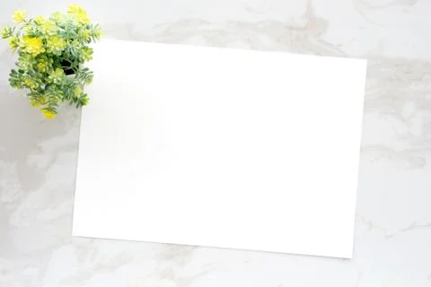 Blank white note paper on white marble background, flat lay, top view, templa Stock Photos