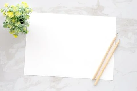 Blank white note papers and pencils on white marble background, copy space fo Stock Photos