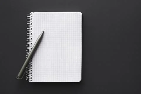 Blank white notebook with pen over grey desktop Stock Photos