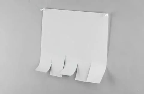 Blank white notepad with torn pages hanging on wall Foto stock