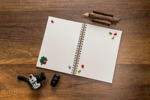 Blank white open note book with orange color pencil, Digital camera and Lens Stock Photos
