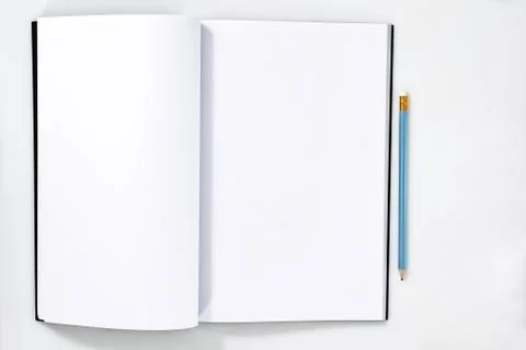 Blank white open notebook or magazine page on white wooden table with pencil on Stock Photos
