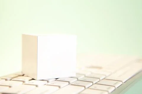 Blank white paper cube on computer keyboard, business and technology concept Stock Photos