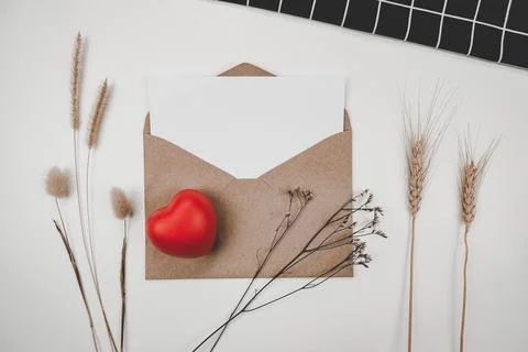 Blank white paper is placed on open brown paper envelope with red heart, Many Stock Photos