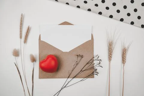 Blank white paper is placed on open brown paper envelope with red heart, Many Stock Photos