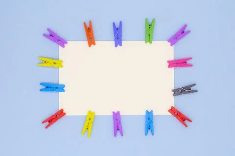 Blank white paper with red clothespins on a blue background Stock Photos
