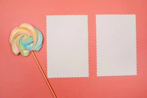 Blank white postcard and rainbow meringue on a stick on a pink background Stock Photos