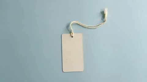 Blank white price tag with string moving on a blue background Stock Footage 341499515