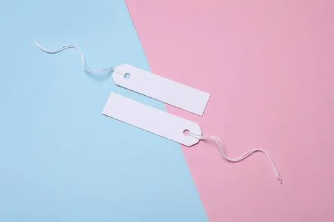 Blank white price tags with string on pink and blue background Stock Photos