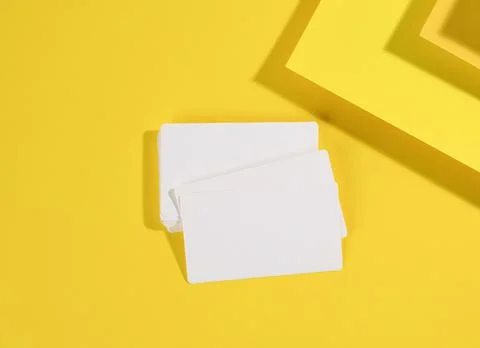 Blank white rectangular business card on creative yellow background from shee Stock Photos