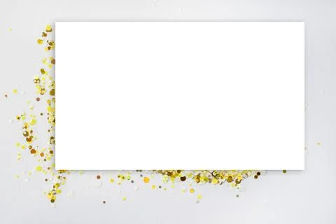 Blank white rectangular card on gold confetti. Space for inscription or design Stock Photos