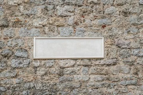 Blank white rectangular plaque on an old stone wall 스톡 사진