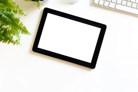 Blank white screen on portable tablet device on modern office desk Stock Photos