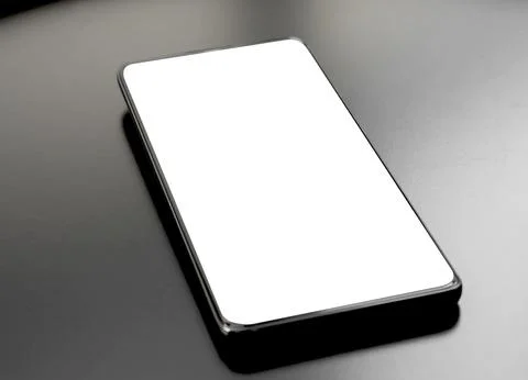Blank white smartphone screen mockup lying flat on a dark metallic table. E.. Stock Photos