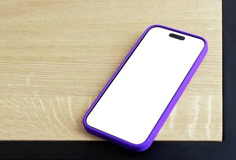 Blank white smartphone screen mockup lying flat at an angle on a wooden tab.. Stock Photos