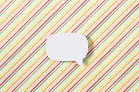 Blank white speech bubble with copy space on a multicolored striped backgroun Foto stock