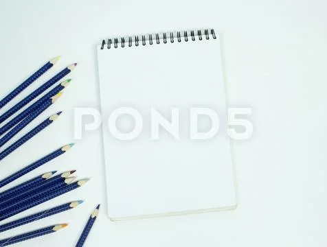 Blank white spiral bound paper drawing pad with color pencil. Isolated on w.. Stock Photos