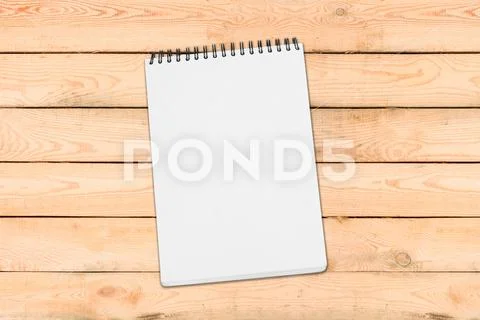 Blank white spiral bound paper drawing pad with shadow isolated on wooden b.. Stock Photos